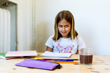 Mischievous girl making funny face while drawing at home