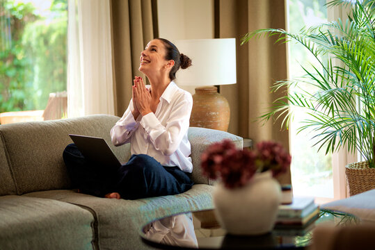 Confident woman sitting at home and using her laptop computer