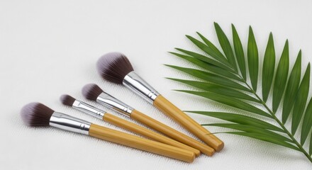 A set of makeup brushes with a green leaf