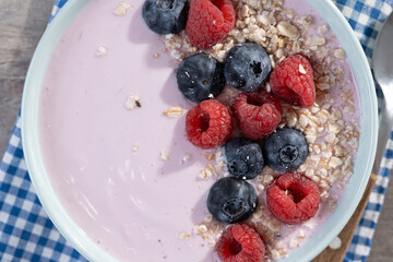 Healthy smoothie bowl with berries on wooden table. Close up