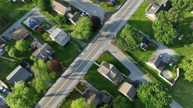 Quiet serene atmosphere in suburb neighborhood of American town. Aerial top down. Roofing flight of houses and homes with well-kept garden at sunset. Summer Days in United States.