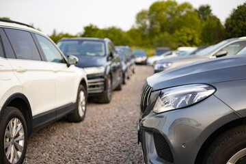 A row of various cars for sale outdoors, potentially at a car dealership. The vehicles are parked...