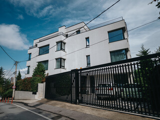 Contemporary architecture featuring a stylish white residential building surrounded by greenery and...