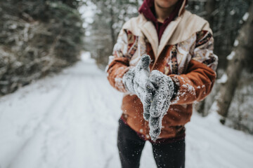 Individual on a serene snow-covered trail with visible snowflakes. Outdoors in winter, showcasing...