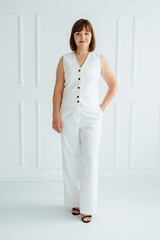 Confident businesswoman posing in stylish white outfit