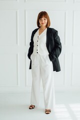 Confident businesswoman posing in stylish white suit and black blazer