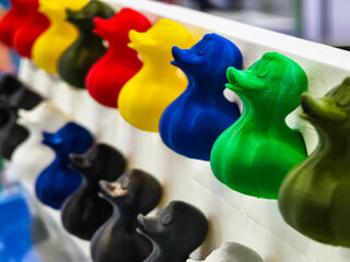 Colorful 3D printed duck figurines displayed at a creative workshop during the afternoon session