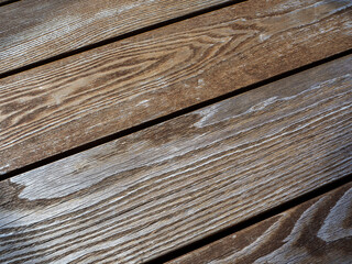 Abstract wooden background with parallel laid boards. The boards are placed diagonally to the background. Copy space.