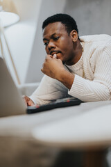 A thoughtful person dressed comfortably, engaged in deep concentration during their work session on...