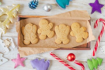 Christmas gingerbread cookies in the shape of a snowman on a white wooden background. Christmas decorations. Top view, flat lay.