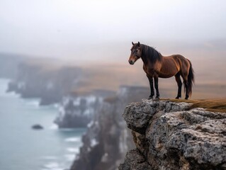 Majestic horse standing on cliffside overlooking the ocean at dawn