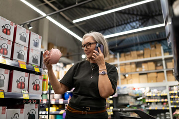Stylish mature woman shopping for home goods in a modern retail store