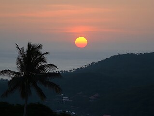 A vibrant sunset paints the sky over distant ocean and land