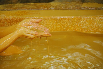 Scooping hot water from Mud Bath with Woman's hands - 泥風呂のお湯をすくう手