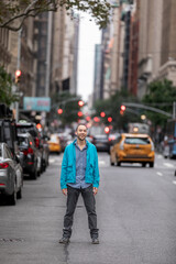 Hispanic Man Smiling On Busy NY City Street With Blurred Traffic And Buildings. Manhattan