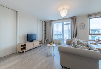 Modern Living Room Interior with Open TV Area and TV on the Wooden Desk, Sofa, And Coffee Table