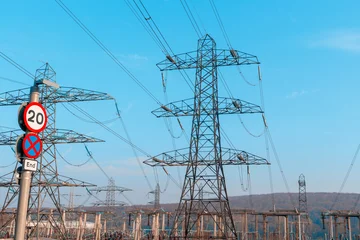 Fototapete Tall power lines dominate the landscape under clear blue sky showing infrastructure that supports everyday life and energy supply © Iryna