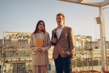Business professionals gathered on a rooftop at sunset, discussing innovative ideas and strategies