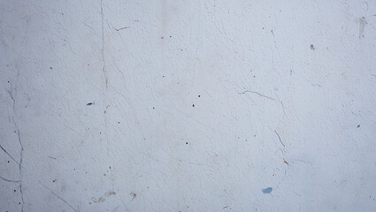 Fototapeta premium Weathered pale blue textured surface with fine cracks and dark speckles cracked