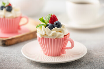 Homemade cupcakes with whipped cream garnished fresh berries for Holidays