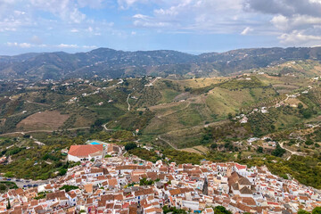 Fototapeta premium FRIGILIANA, SPAIN - MAY 10, 2025: A peaceful walk through the charming narrow streets, surrounded by whitewashed houses and colorful flowers in Frigiliana, Spain