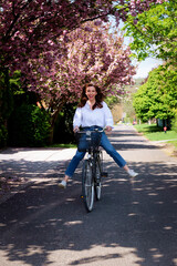 Confident middle aged woman riding bicycle on the street