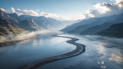 A river winding through mountainous landscape with clouds and mist in the background.