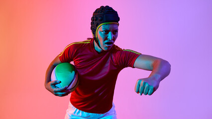 Energetic female athlete playing rugby under dynamic multicolored lighting. Concept of modern athlete visualization, edgy performance look