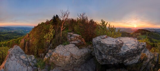 Sunset in a rocky landscape with spring green nature. Stiavnicke hill, Sitno, Slovakia. Stone hilltop at sunset.