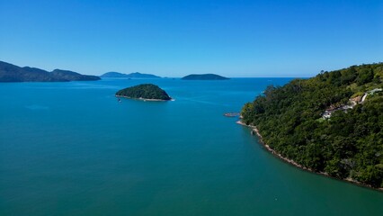 Vista aérea de ilhas tropicais rodeadas por mar azul e vegetação exuberante num dia claro. Paisagem natural perfeita para temas relacionados com turismo, natureza e tranquilidade.