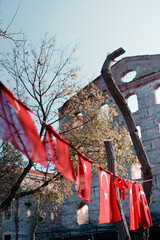 Historic ruins with Turkish flags lined across, showcasing cultural pride on a rural backdrop....