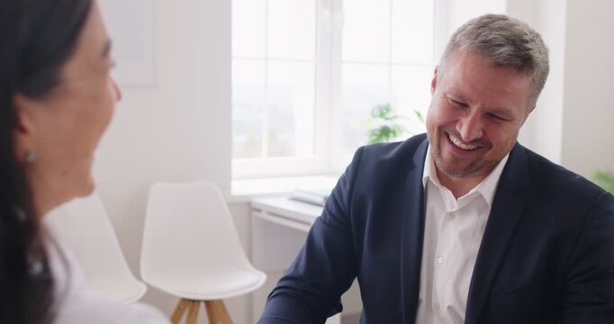 Two happy, smiling businesspeople make a successful business deal and give each other high fives. Concept of cooperation, teamwork, partnership and agreement