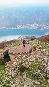 Man on top of Mount Vrmac near Bay of Kotor, Montenegro - drone view.