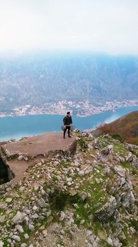 Man on top of Mount Vrmac near Bay of Kotor, Montenegro - drone view.