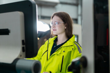 women engineer using computer control panel cnc machine at workshop. technician Female control...