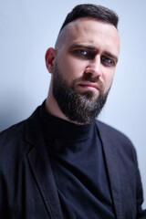 Studio portrait of young handsome man with beard.