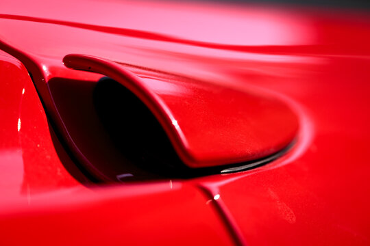 Rear side closeup detail of a famous red Italian supercar. Rosso corsa is the red international motor racing colour of cars entered by teams from Italy