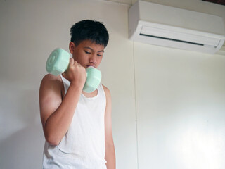 Exercise & Wellness, Youngster doing exercise with dumbbell, Asian teenage boy in white tank top...