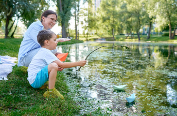 Mother Teaching Son to Float Paper Boats in a Serene Lakeside Setting