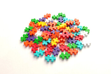 Stack of colorful jigsaw puzzle on white background