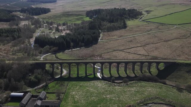 Aerial view of the viaduct cutting across the landscape, its arches casting shadows on the verdant ground below, Hawick, Scotland, United Kingdom.