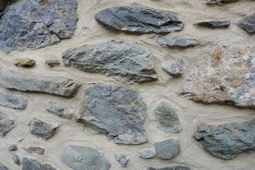 Textures of a rustic stone wall showcase a variety of shapes and colors