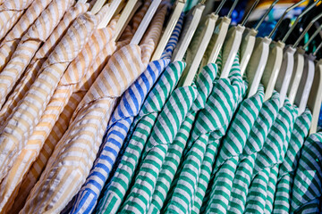Colorful display of clothing on hangers in a retail store showcasing a variety of styles and...