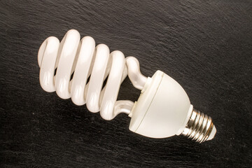 One LED lamp on slate stone, macro, top view.