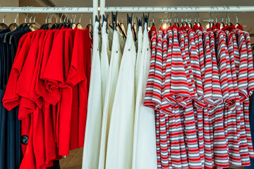 Colorful display of clothing on hangers in a retail store showcasing a variety of styles and...