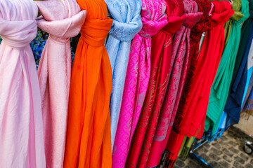 Colorful collection of scarves hanging in a market stall on a sunny day