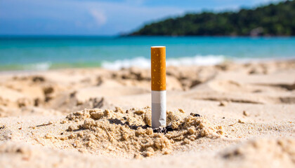Burnt cigarette butt lying on sandy beach. Environmental pollution.