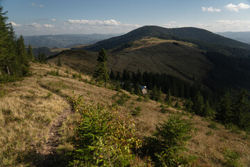 Scenic landscape view from a hillside trail with distant mountains and a blue sky. Hiking in...