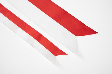 The striped red and white ribbon of the Indonesian flag on a white background. Concept of Indonesian Independence Day or Kemerdekaan