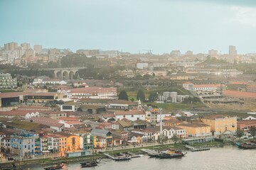 People explore Porto’s historical architecture along the Douro River. Traditional boats bob at the Ribeira waterfront with colourful buildings in this scenic Portuguese city
